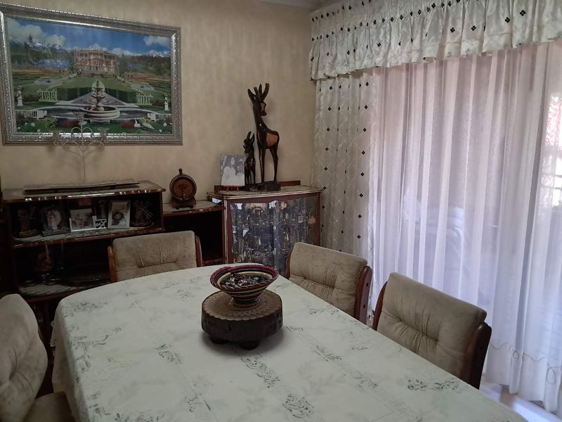 A dining room area featuring a sliding door with curtains, providing access to the exterior.