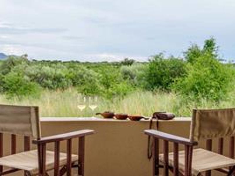 A peaceful patio area overlooking the expansive natural landscape and surrounding bushveld, offering a serene outdoor space for relaxation.