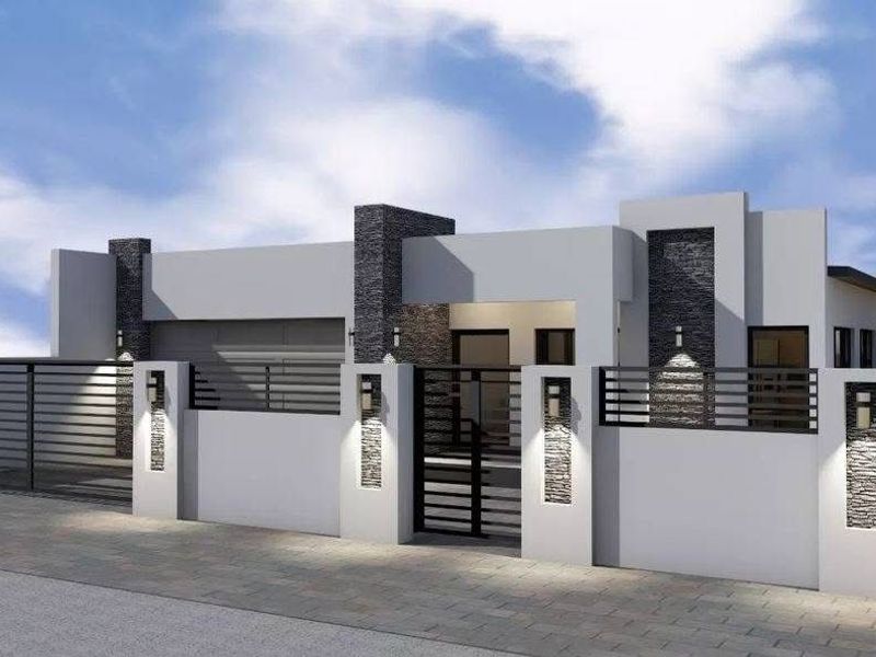 Modern residential facade featuring clean architectural lines, stone-clad pillars, integrated wall lighting, and a secure gated entrance.