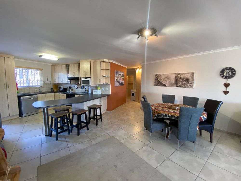 Open-plan kitchen and dining area. Hallway leading to bedrooms 