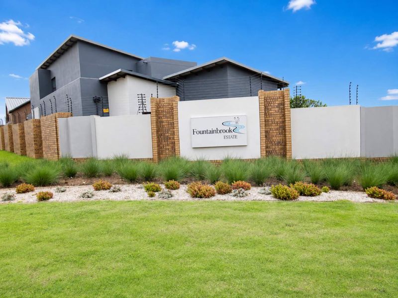 The entrance to Fountainbrook Estate featuring a modern perimeter wall, integrated estate signage, and well-maintained landscaped garden beds.