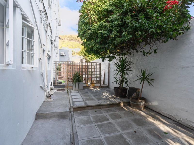 A private rear courtyard featuring paved flooring and a timber lattice screen, offering a quiet outdoor space for the apartment.