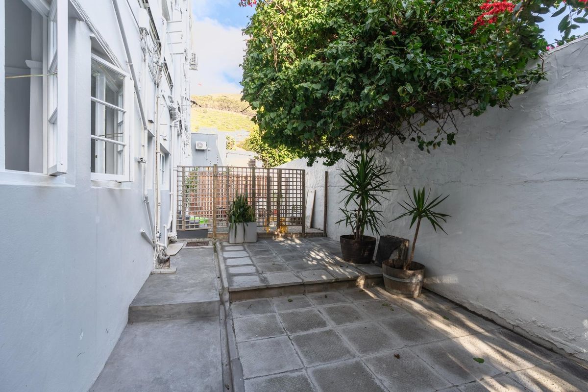 A private rear courtyard featuring paved flooring and a timber lattice screen, offering a quiet outdoor space for the apartment.