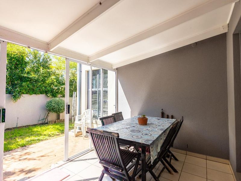 A covered patio area featuring tiled flooring and sliding glass doors that open onto a private garden space.