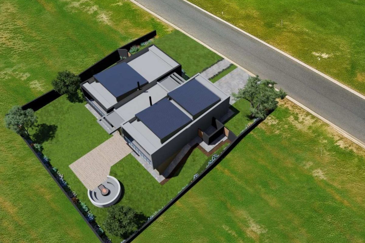 Aerial view of a modern residential property featuring solar panels, a paved driveway, and a landscaped garden with a circular fire pit area.