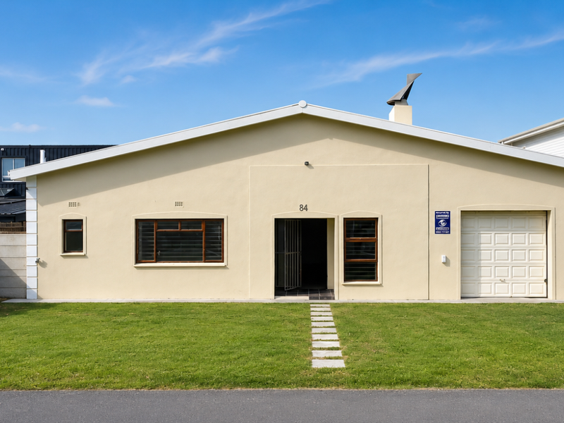 Front elevation of a single-story house featuring a paved walkway, integrated garage, and a well-maintained front lawn.