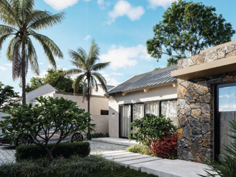 Modern residential exterior featuring stone cladding, metal roofing, and a paved driveway with landscaped garden elements.