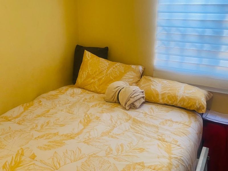 A compact bedroom featuring a window with fitted blinds, providing natural light to the space.