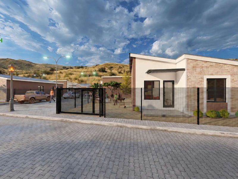 A modern residential development featuring paved driveways, secure perimeter fencing, and contemporary brick-accented facades in a landscaped estate setting.