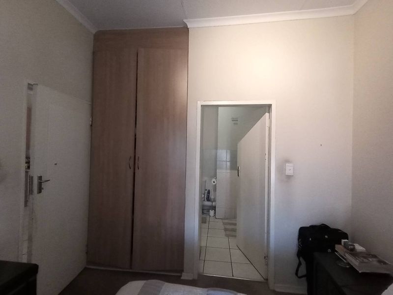 A bedroom featuring a built-in wardrobe and direct access to an en-suite bathroom, with standard finishes and cove cornicing.