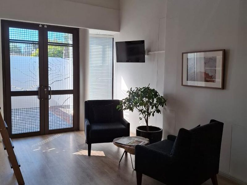 Bright office space featuring vaulted ceilings, laminate flooring, and a distinctive stained glass window, providing a welcoming and professional atmosphere.