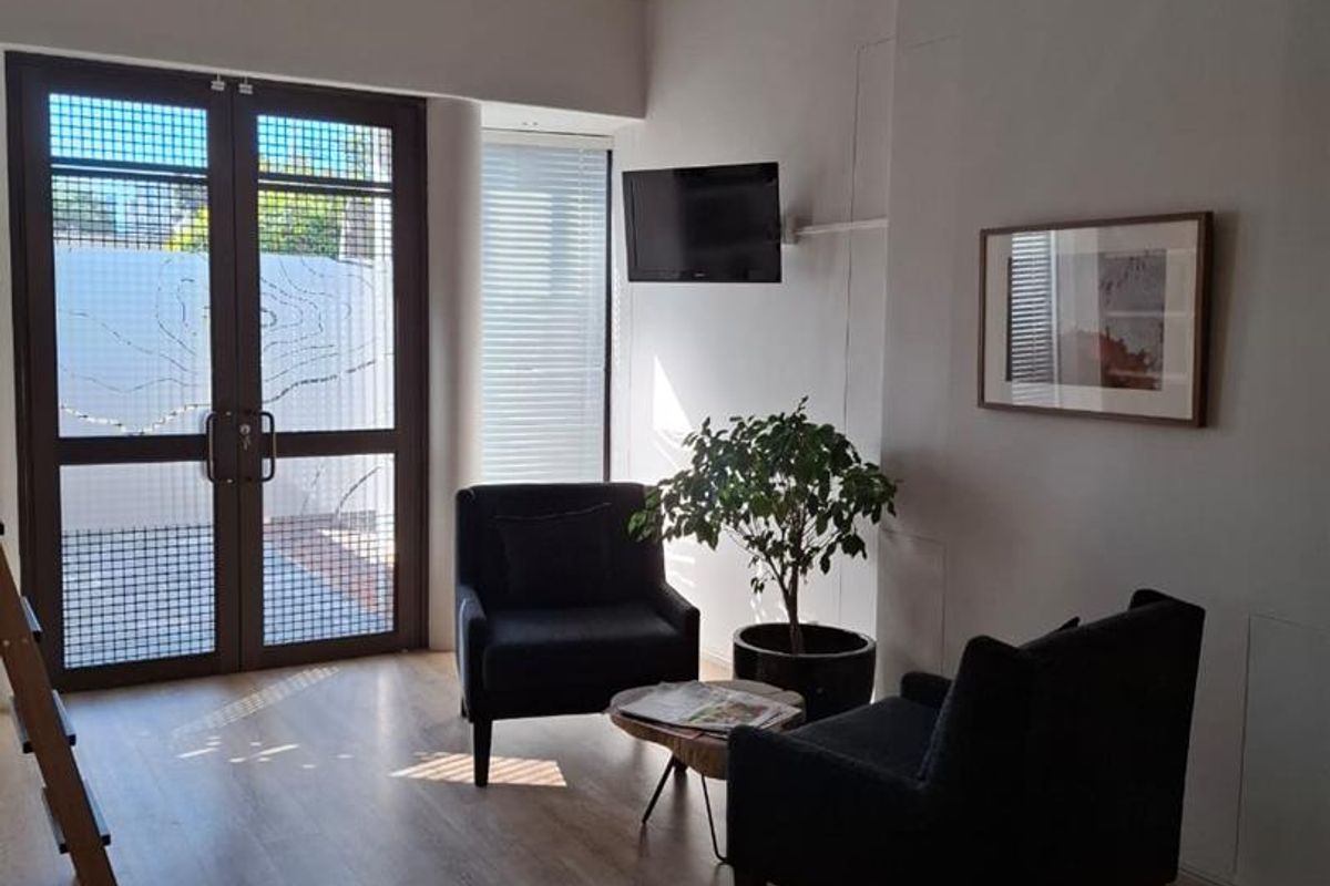Bright office space featuring vaulted ceilings, laminate flooring, and a distinctive stained glass window, providing a welcoming and professional atmosphere.