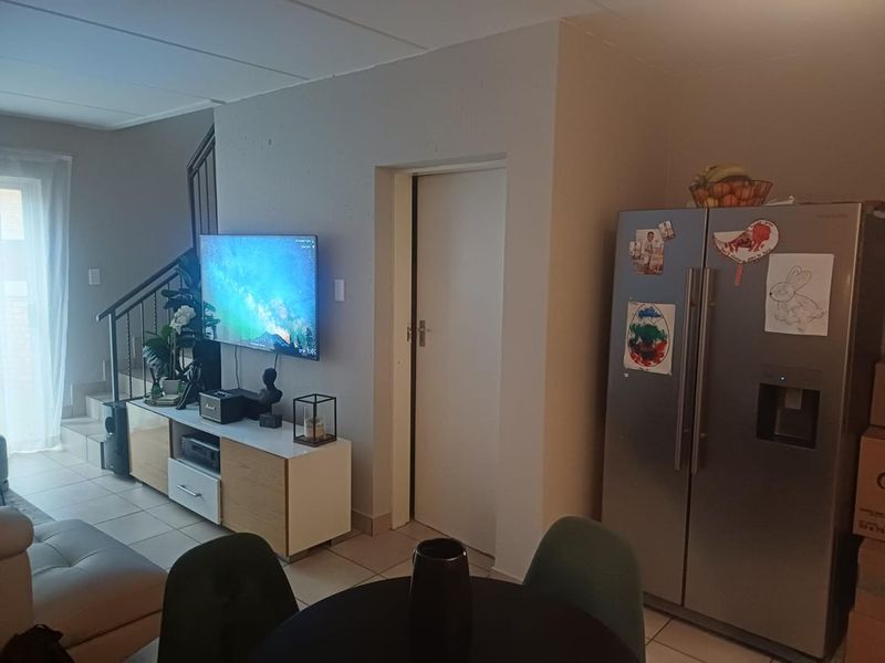 Open plan living area featuring tiled flooring and a staircase leading to the upper level.