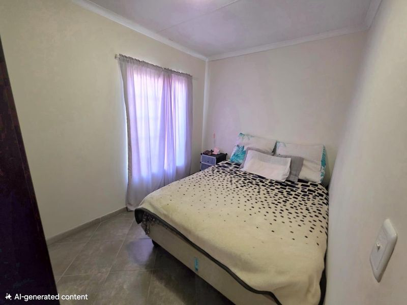 A compact bedroom featuring tiled flooring and neutral wall finishes, providing a functional space with natural light from the window.