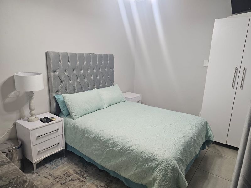 A well-maintained bedroom featuring tiled flooring and a built-in wardrobe, offering a clean and functional living space.