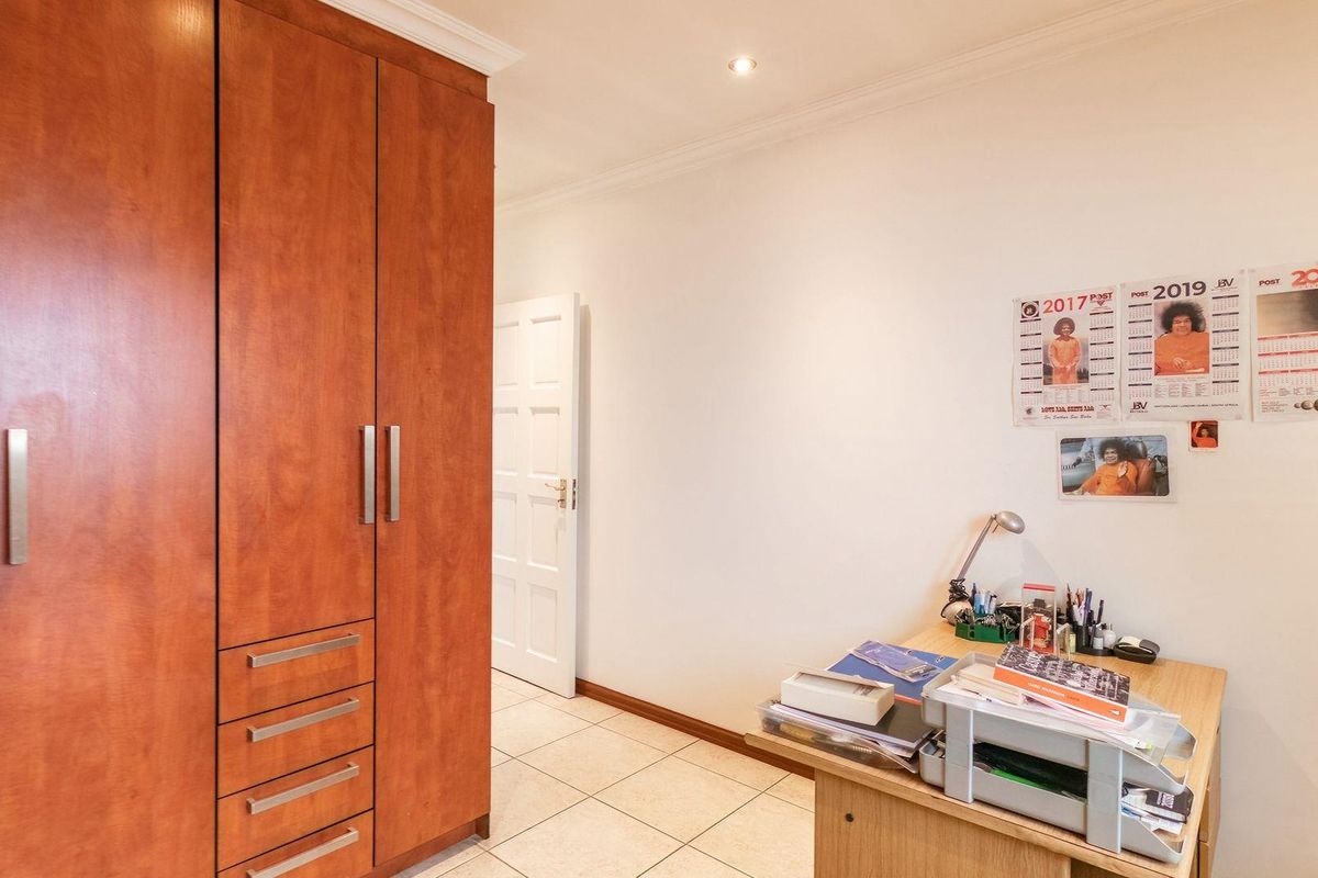 A bedroom featuring built-in wooden cabinetry with integrated drawers and tiled flooring.