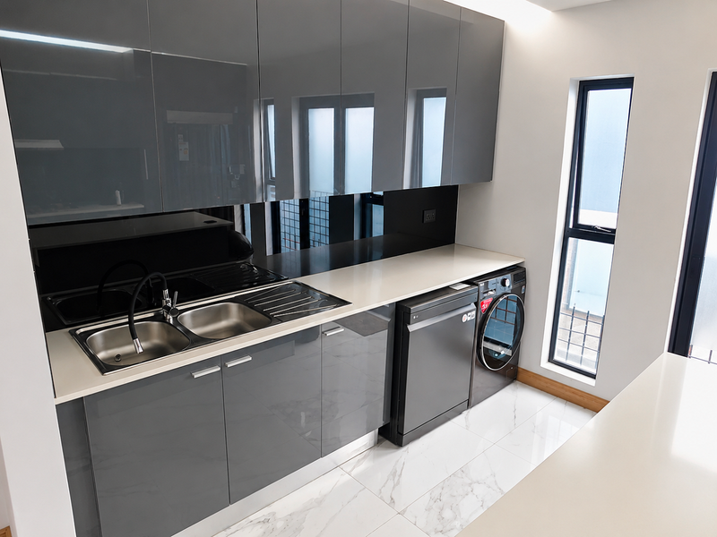 Modern scullery featuring sleek grey cabinetry, stone countertops, a double stainless steel sink, and high-end marble-look floor tiles.