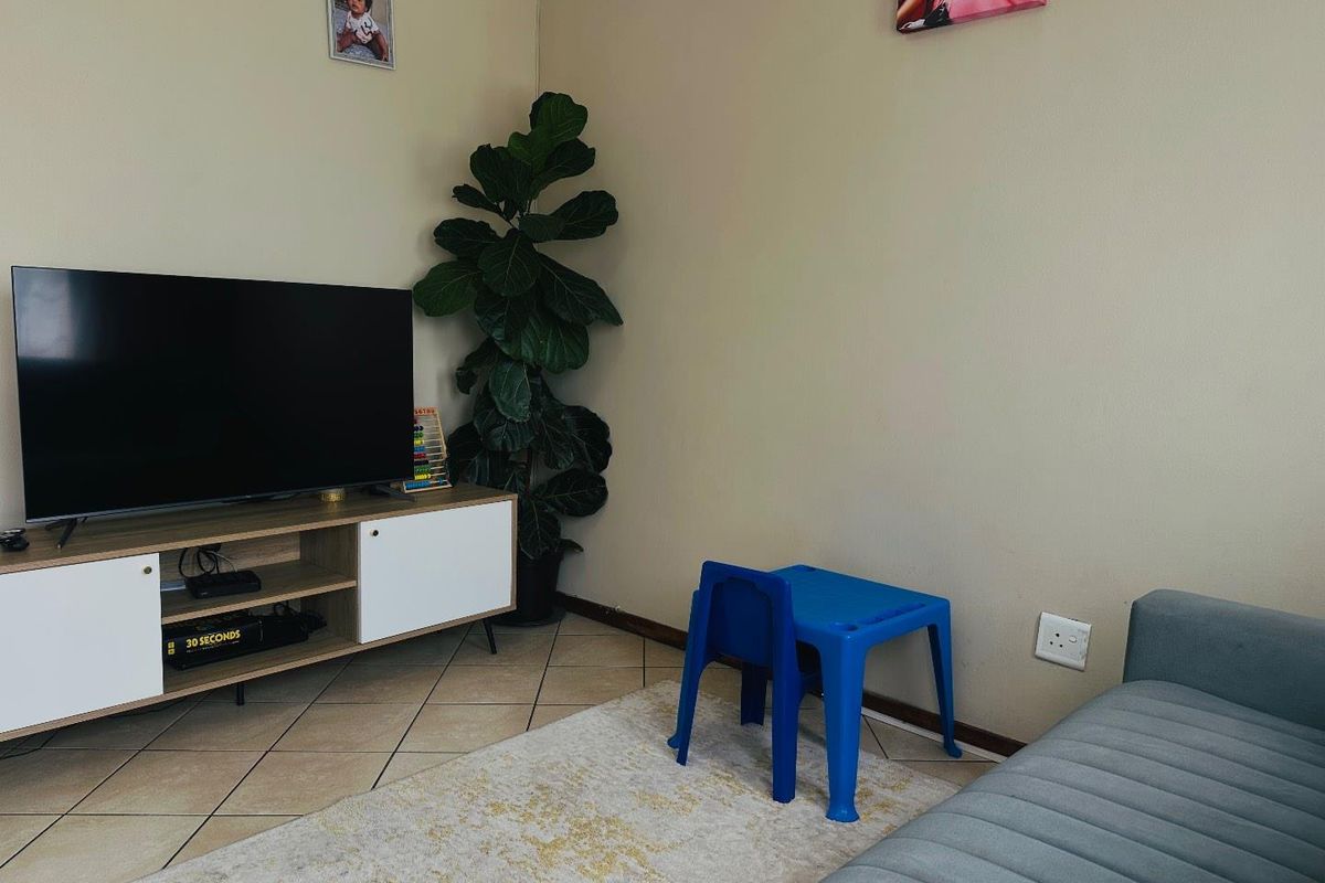 A living room area featuring tiled flooring and neutral wall finishes, providing a functional space for relaxation.