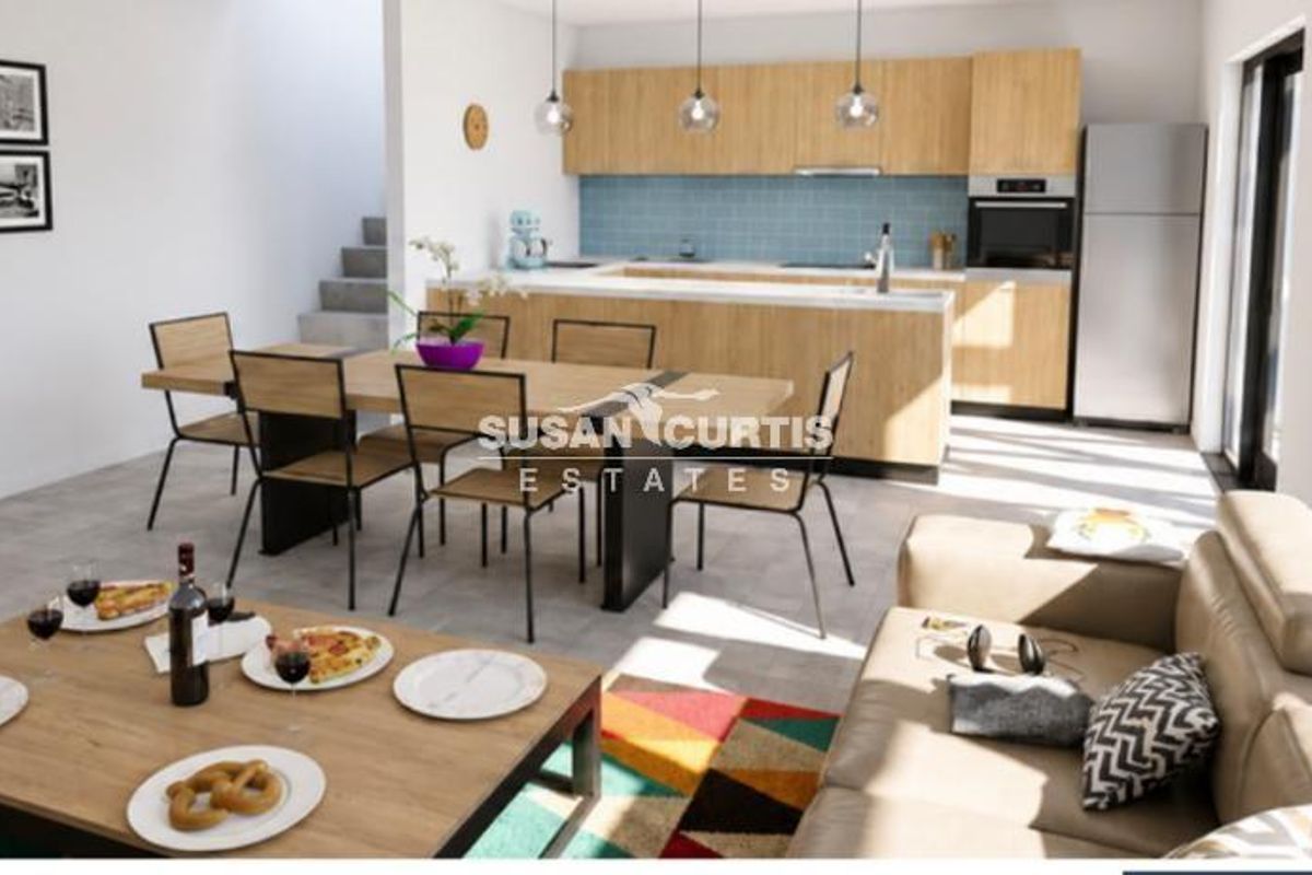 Modern open-plan living area featuring a contemporary kitchen with light wood cabinetry, integrated appliances, and a seamless flow to the dining and lounge spaces.