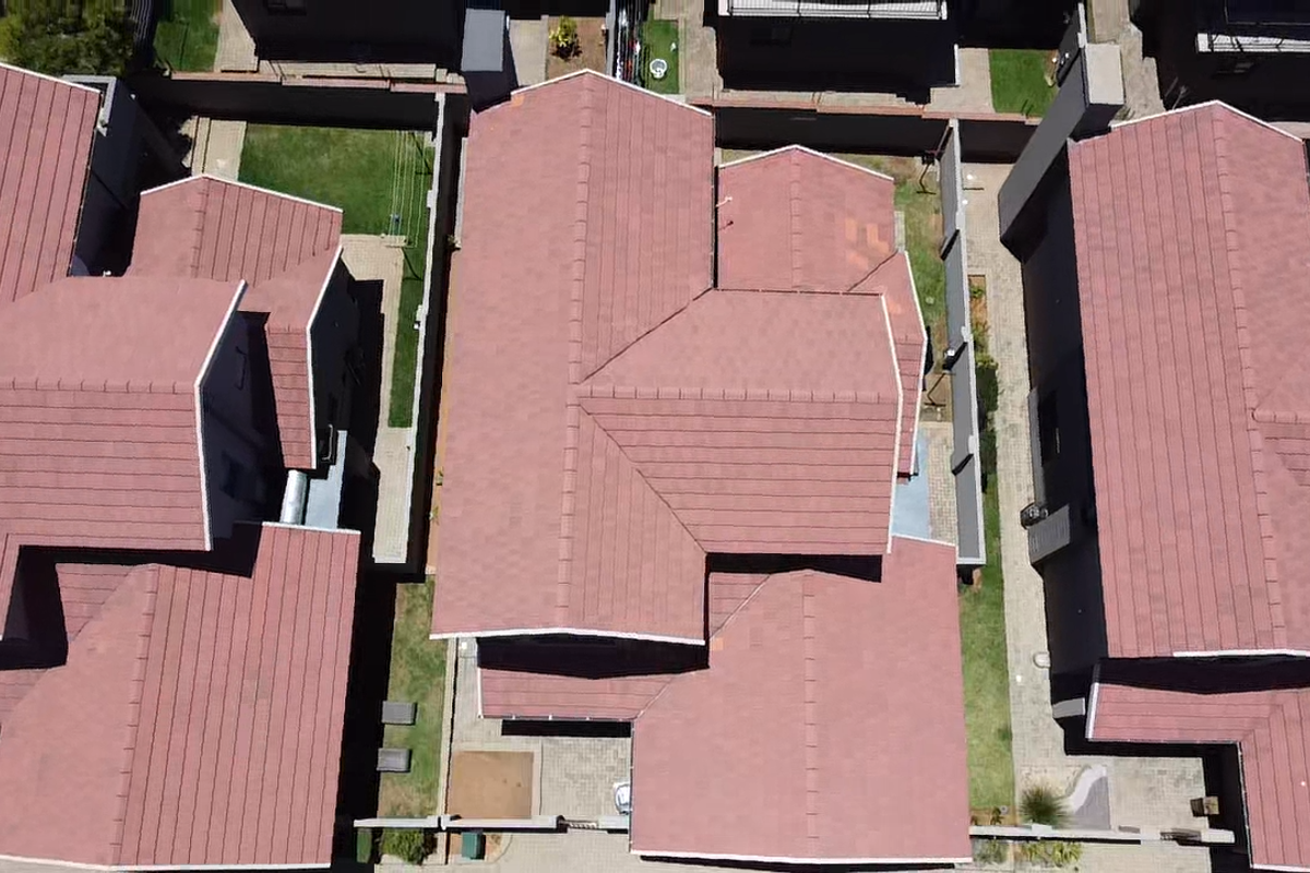 Aerial view of the property showing the tiled roof structure and surrounding residential garden spaces.