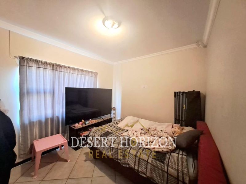 A standard bedroom featuring tiled flooring and simple ceiling finishes, providing a functional space for rest.