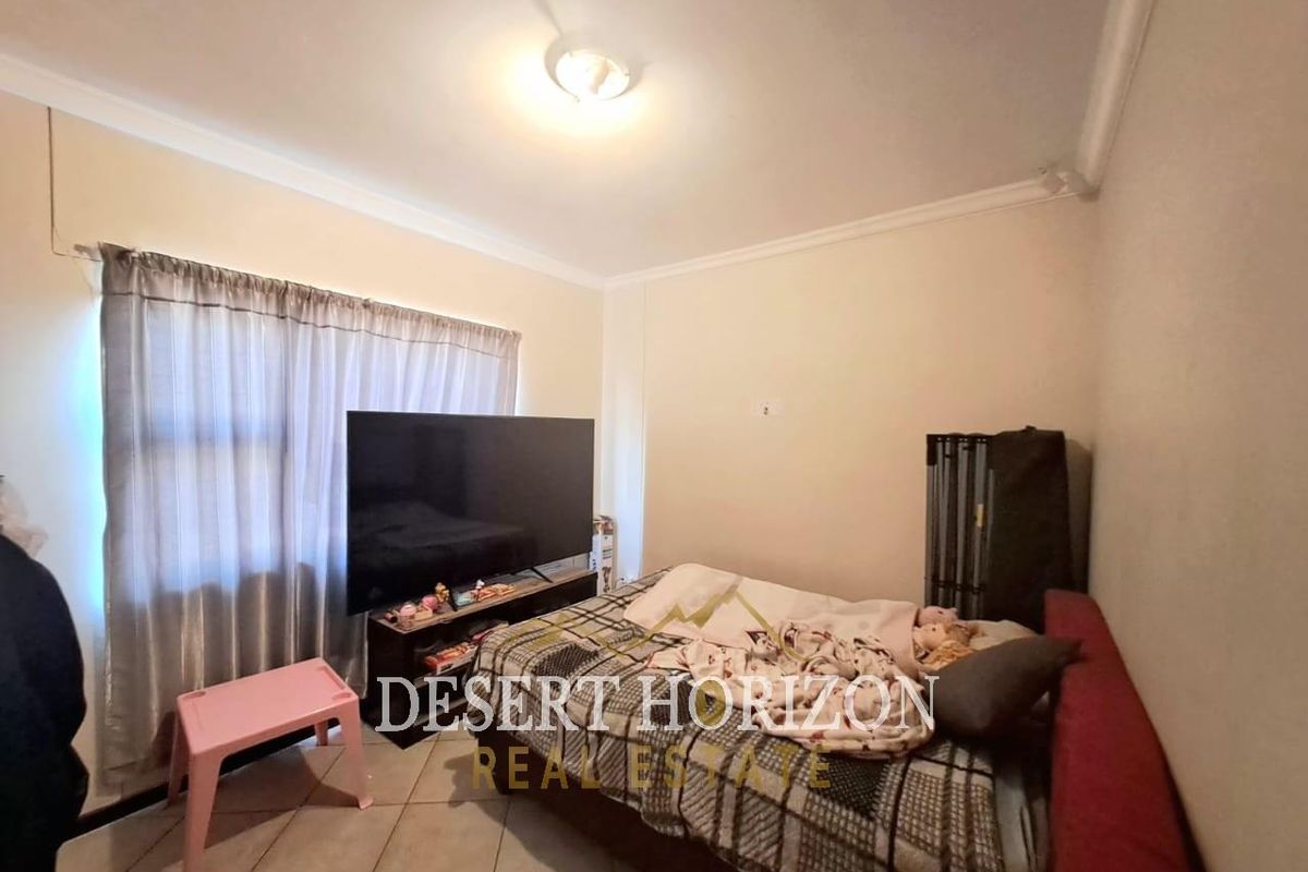 A standard bedroom featuring tiled flooring and simple ceiling finishes, providing a functional space for rest.
