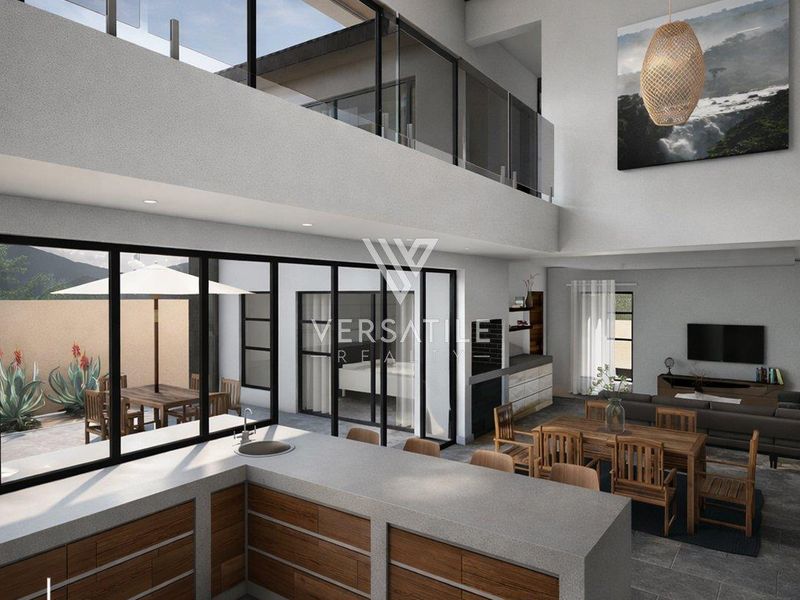 Spacious open-plan living area featuring a modern kitchen with stone countertops, exposed timber beams, and seamless indoor-outdoor flow through large glass sliding doors.