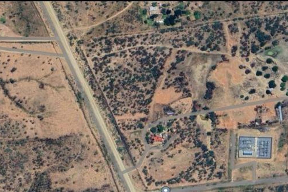 An aerial view of the small holding property showing the surrounding landscape, access roads, and existing structures on the plot.