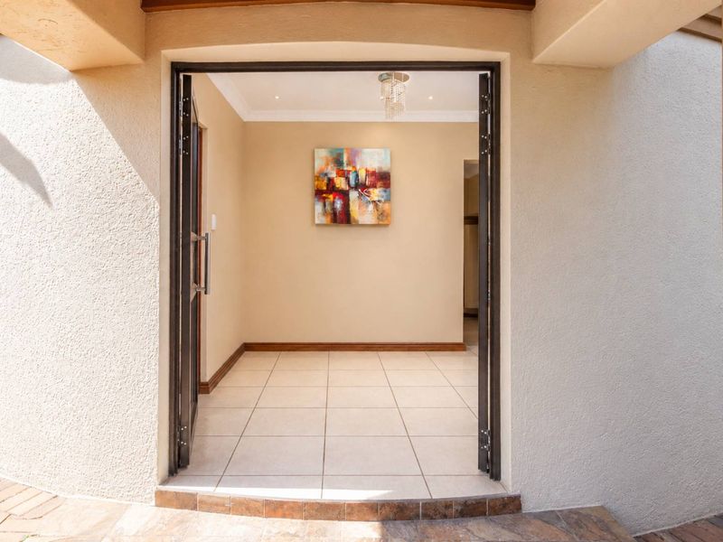 A bright and welcoming entrance hall featuring neutral tiled flooring, recessed lighting, and a clean, open layout leading into the home.