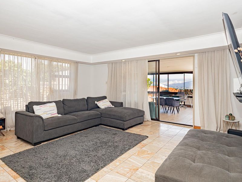 Spacious living room featuring tiled flooring and large sliding glass doors that provide access to an outdoor patio area.
