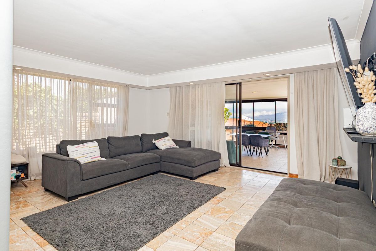 Spacious living room featuring tiled flooring and large sliding glass doors that provide access to an outdoor patio area.