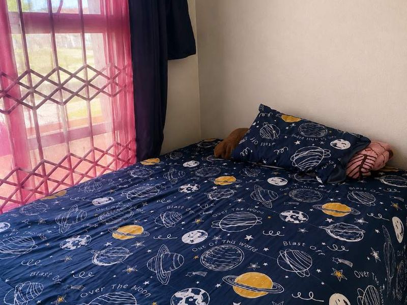 A bedroom featuring tiled flooring and a window with decorative curtains.