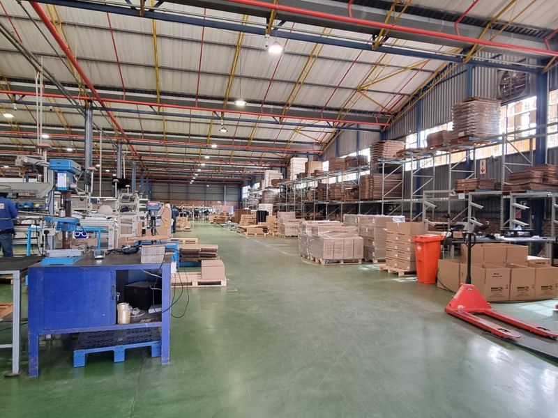 Spacious industrial warehouse facility featuring high-clearance ceilings, exposed steel trusses, polished concrete flooring, and integrated racking systems for efficient storage and operations.