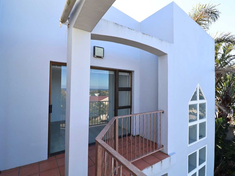 A private balcony featuring tiled flooring, a metal balustrade, and sliding glass door access, offering an outdoor space with potential for seating.