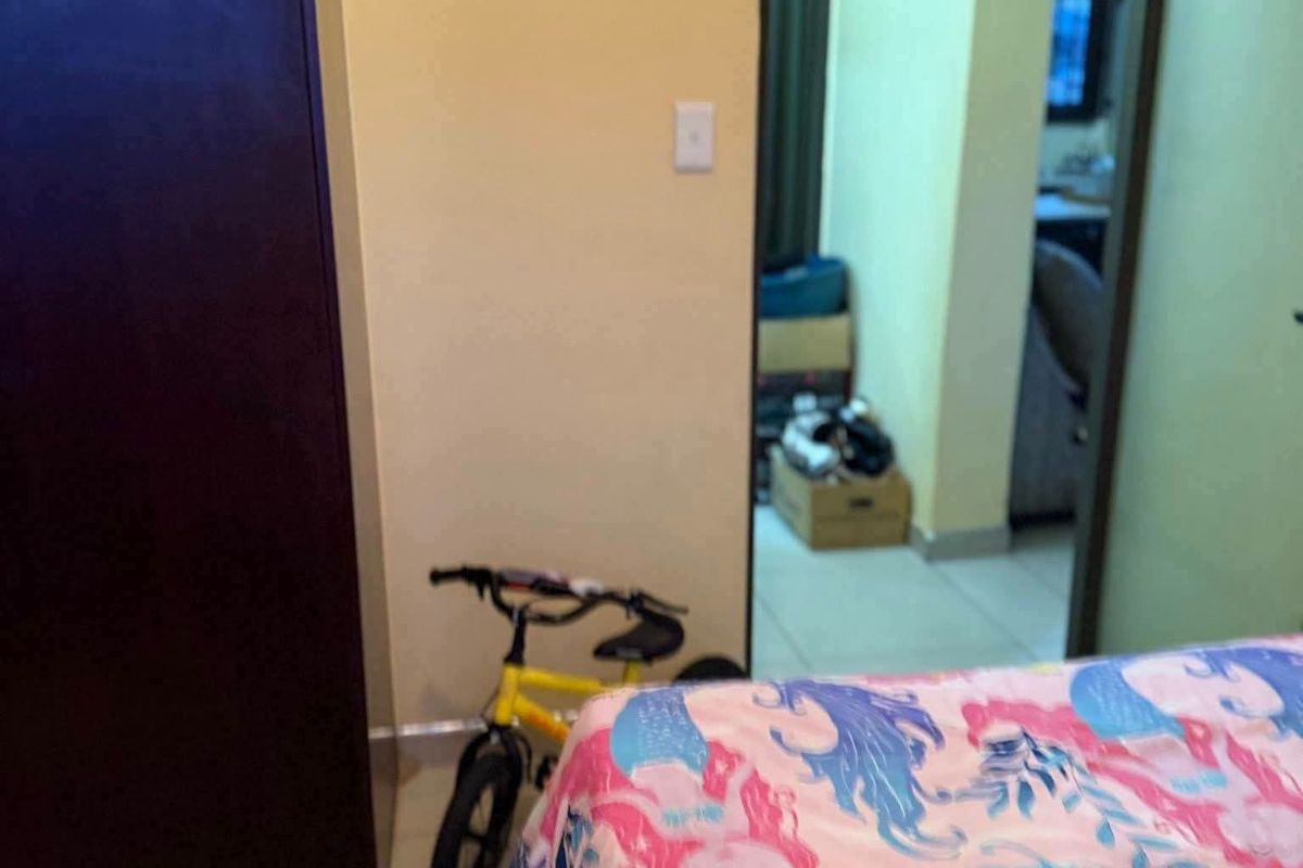 A bedroom featuring tiled flooring and a built-in wardrobe, with a doorway leading to an adjacent living area.
