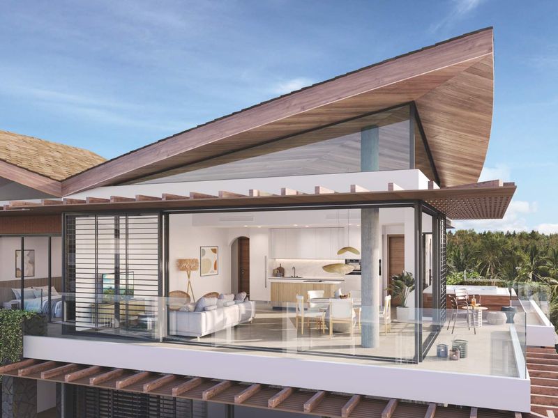 A modern penthouse open-plan living area featuring floor-to-ceiling glass walls, a sleek kitchen, and a spacious private balcony with architectural timber detailing.