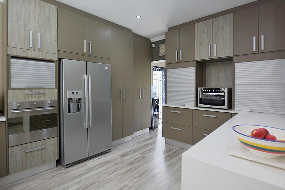 Modern kitchen featuring sleek cabinetry, integrated oven, built-in microwave, and stone countertops with a clean, contemporary finish.