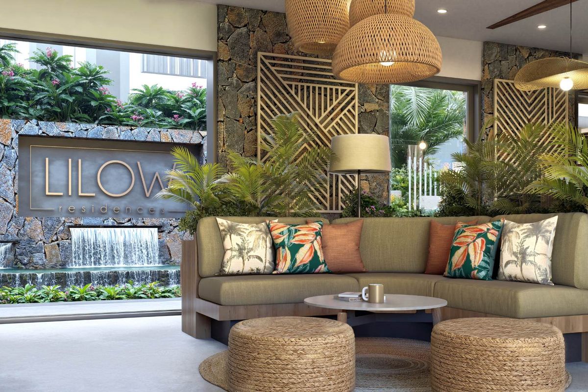 A modern, well-appointed lounge area featuring natural stone wall accents and a view of an outdoor water feature.