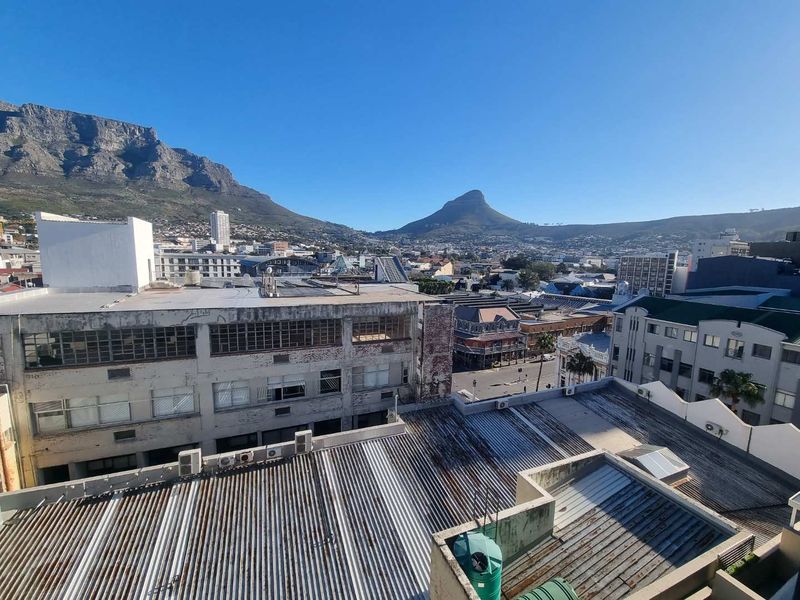 Elevated urban view overlooking surrounding buildings with Table Mountain and Lion's Head in the background.