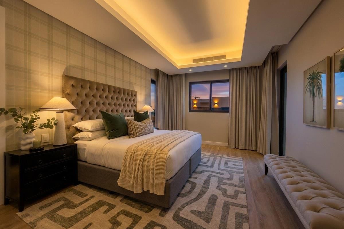 A well-appointed bedroom featuring a recessed ceiling with integrated cove lighting, ducted air conditioning, and modern laminate flooring.
