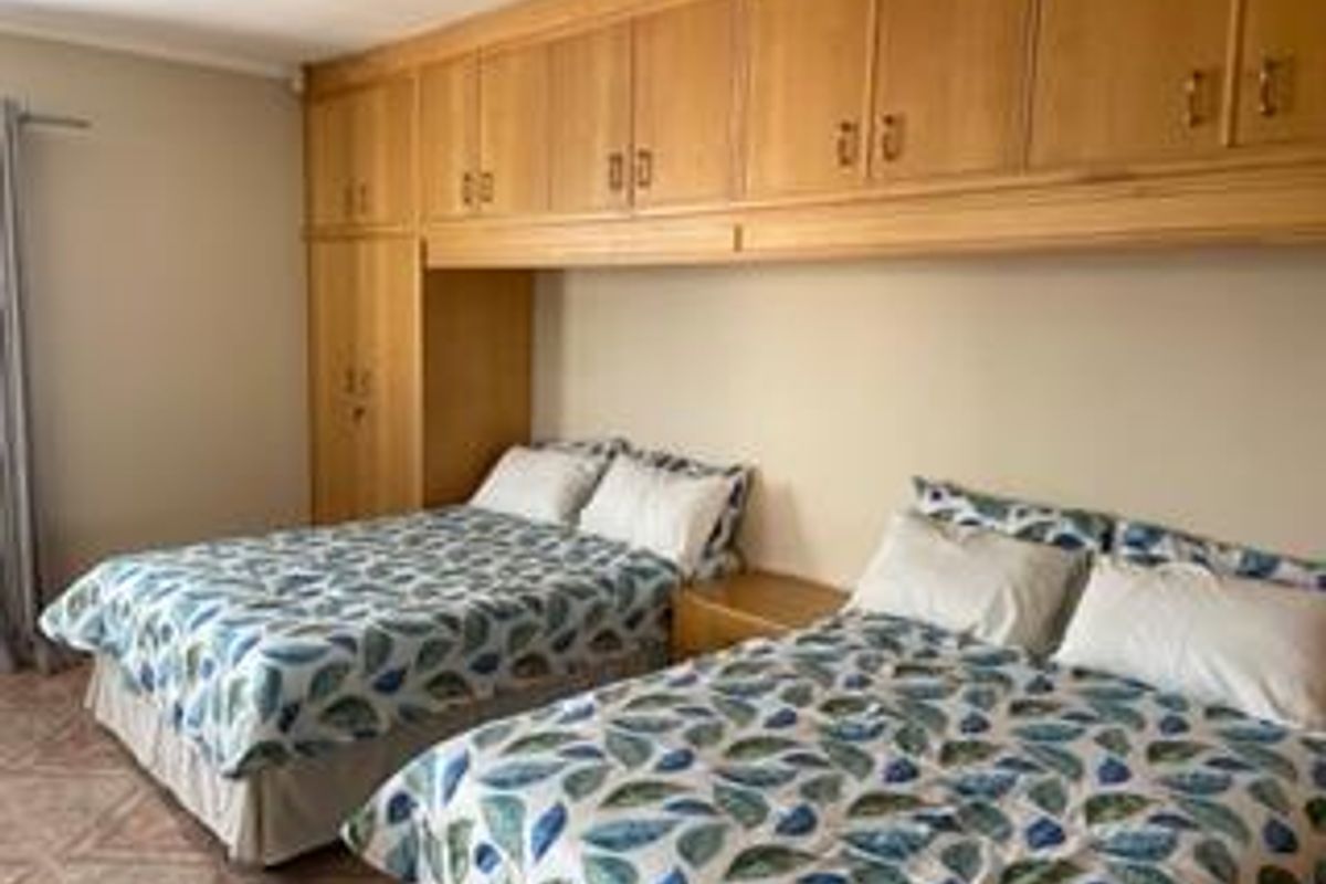 A bedroom featuring extensive built-in wooden cabinetry and tiled flooring.