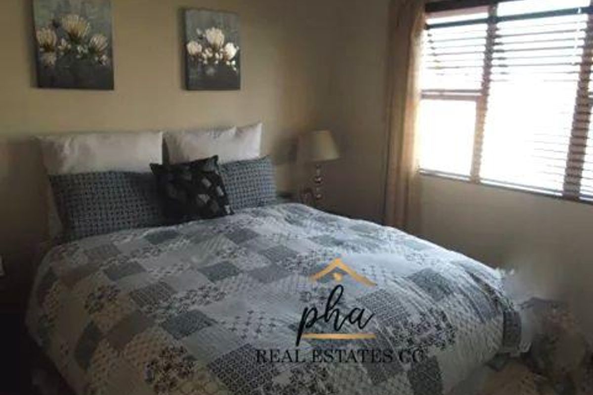 A standard bedroom featuring a window with fitted blinds, providing natural light and a neutral interior finish.