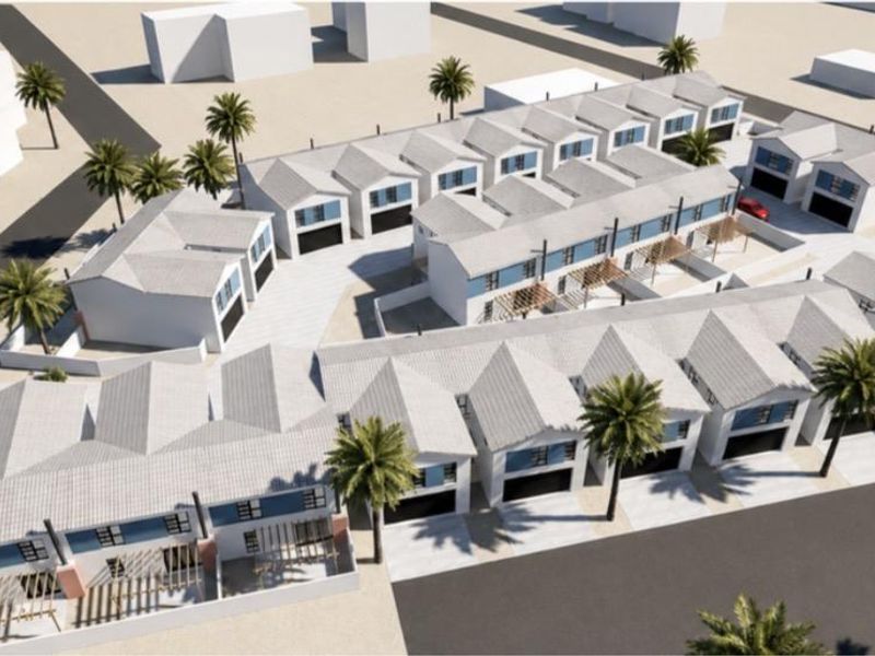 An aerial 3D render showing the layout and architectural design of a modern townhouse complex with multiple units, driveways, and landscaped areas.