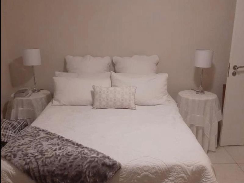 A simple bedroom featuring tiled flooring and neutral wall finishes.