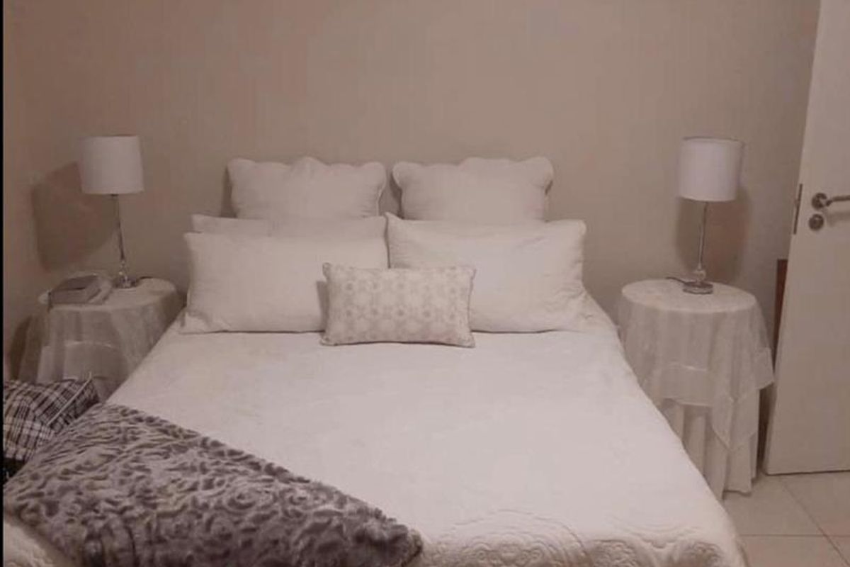 A simple bedroom featuring tiled flooring and neutral wall finishes.