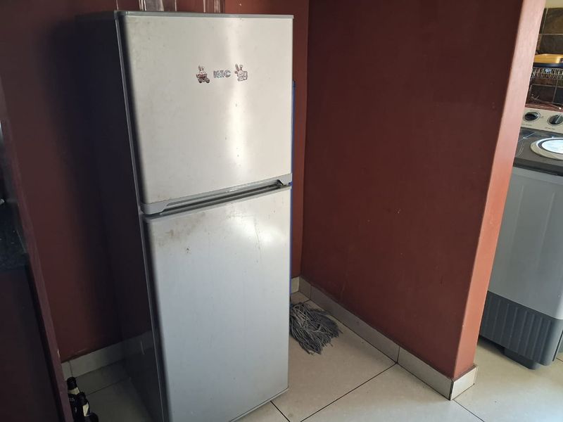 A functional laundry or utility area featuring tiled flooring and neutral wall finishes, providing space for essential household appliances.