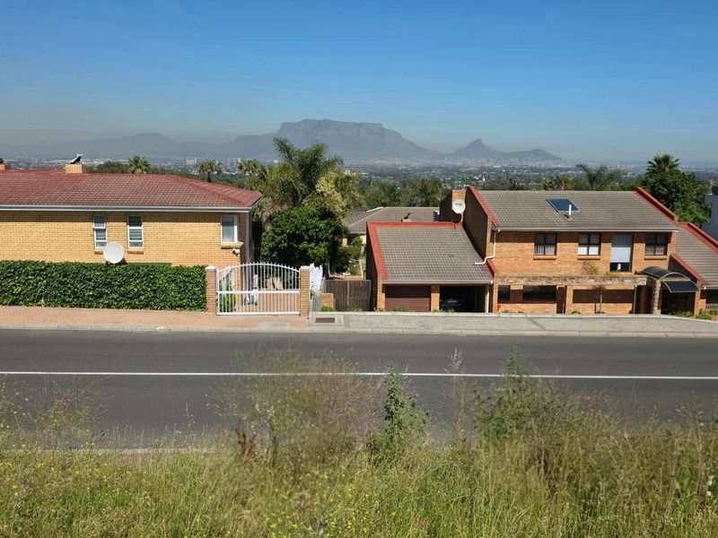 A clear view of the surrounding residential neighbourhood and distant mountain range from the vacant land plot.
