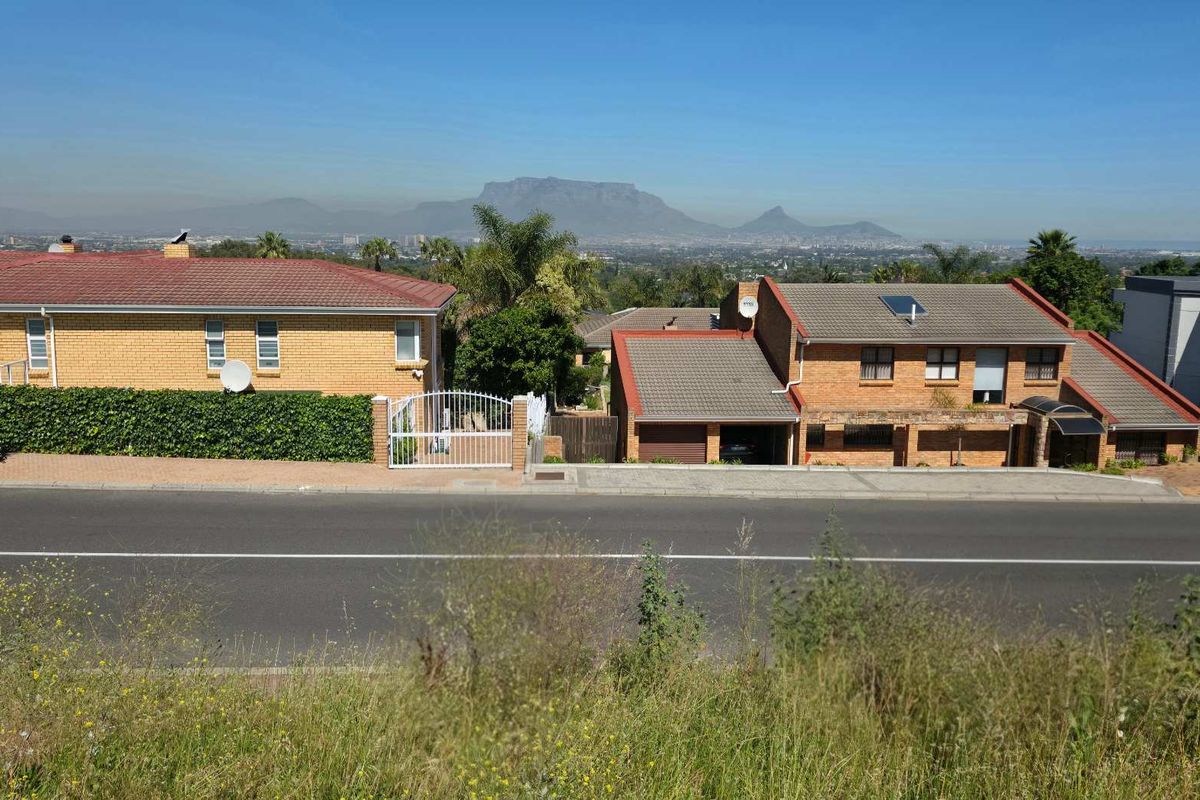 A clear view of the surrounding residential neighbourhood and distant mountain range from the vacant land plot.