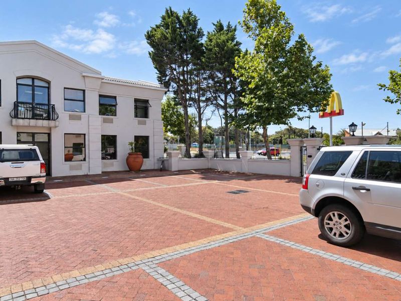 Front exterior view of a professional office building featuring a brick-paved parking area and a well-maintained multi-story facade.