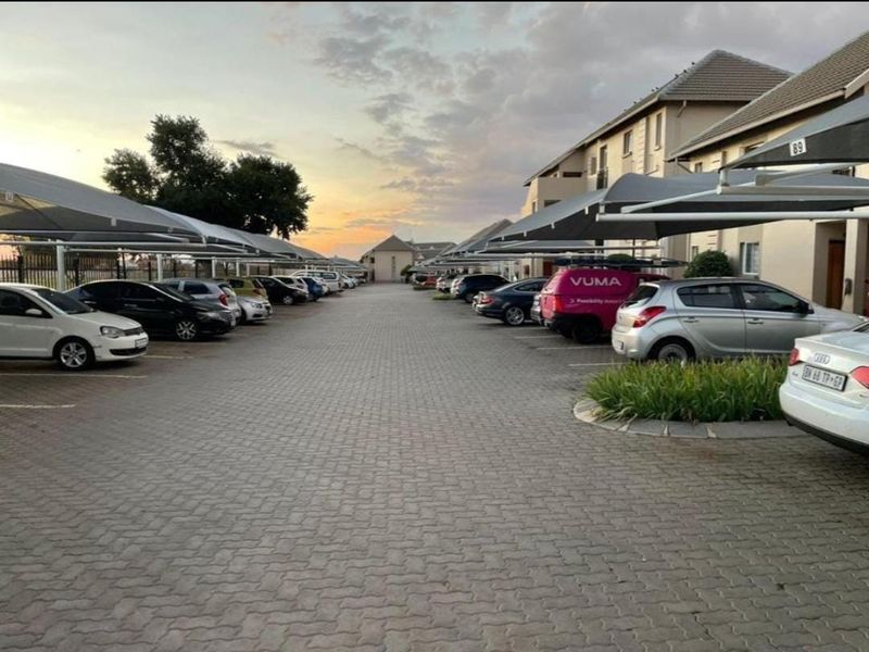 Exterior view of the apartment complex parking area featuring paved driveways and covered parking bays.